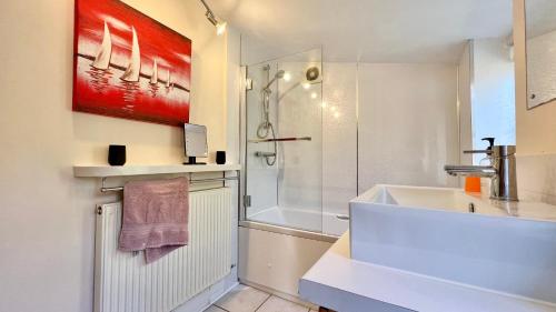 a white bathroom with a shower and a sink at 3 Bedroom Character Townhouse on Edge of Blackdown Hills in Wellington