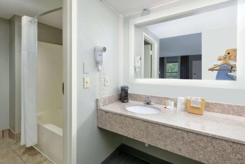a bathroom with a sink and a mirror at Super 8 by Wyndham Diberville Biloxi Area in Biloxi