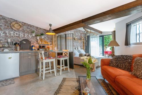 un salon avec un canapé rouge et une cuisine dans l'établissement Lodge Berik - Loft pour 2 avec piscine, à Comps