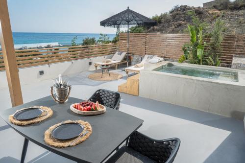 a table with a bowl of fruit on top of a patio at Mnḗmē Suites & Villas in Kastrí