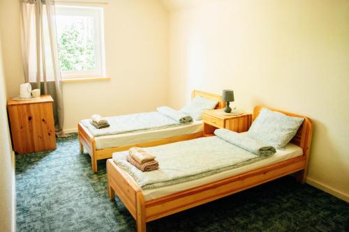 2 camas individuales en una habitación con ventana en Beach Bus Hotel en Roja