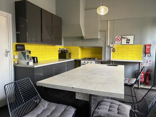 a kitchen with a table and two chairs in it at Cricketers Hostel in London