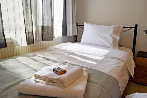 uma cama com toalhas e um controlo remoto em Electra apartment Agia Triada em Hagia Triada