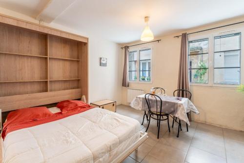 une chambre avec un lit, une table et des chaises dans l'établissement Studio tout confort au Ventoux, à Malaucène