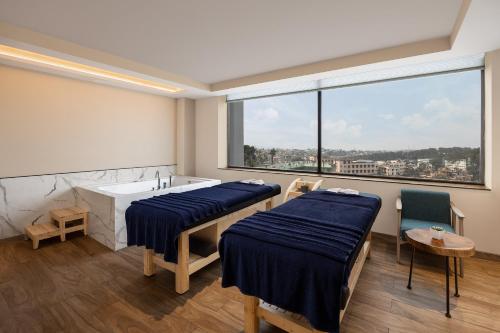 a room with two beds and a tub and a window at Courtyard by Marriott Shillong in Shillong