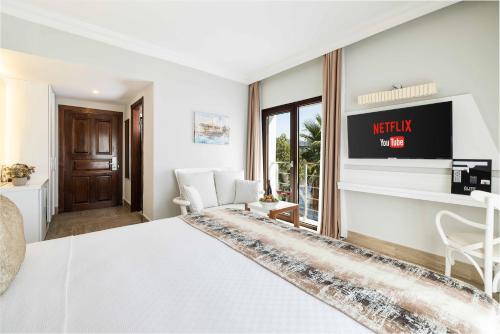 a hotel room with a bed and a tv at Elite Hotel Yalıkavak in Yalıkavak