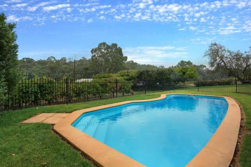a swimming pool in a yard with a fence at Woodlands - Vineyard setting in Penwortham