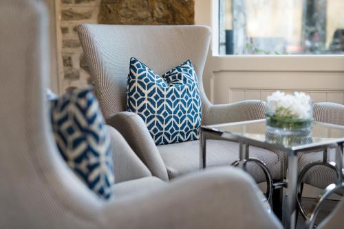 a living room with blue and white pillows and a table at Dunalastair Hotel Suites in Kinloch Rannoch