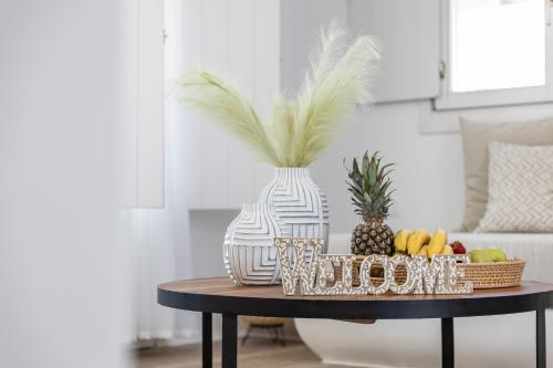 a table with a bowl of fruit and a vase at Arsenis Luxury Villas in Plaka