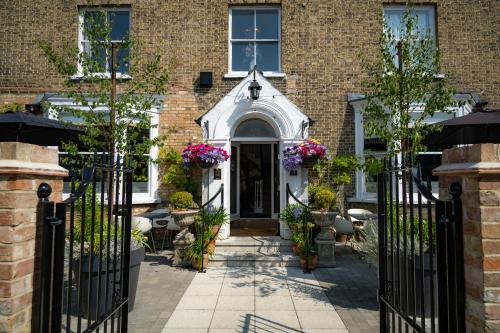 uma casa de tijolos com um portão com flores em The Bramley House Hotel em Chatteris