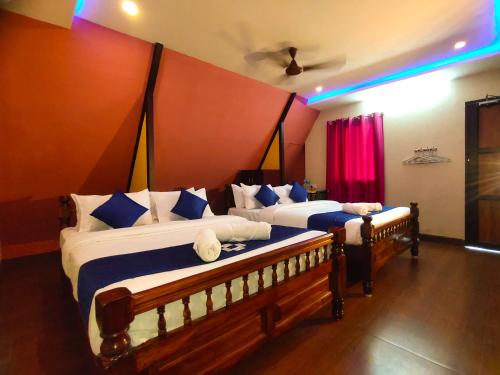 a bedroom with two beds with blue and white pillows at PV Cottages - Serenity Beach in Puducherry