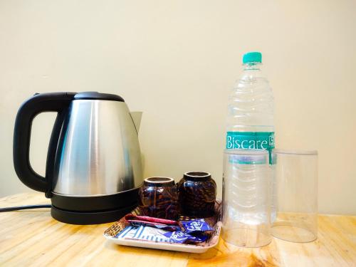 a tea kettle and a bottle of water on a table at PV Cottages - Serenity Beach in Puducherry