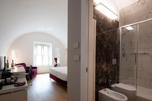 a bathroom with a bed and a shower and a sink at Le Stanze Del Savonarola in Ferrara