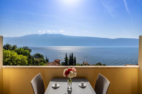 a table with a vase of flowers on a balcony at Hotel Meandro - Lake View in Gargnano