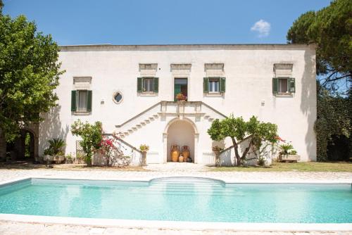 una casa con una piscina di fronte di Villa Encantamiento - Dimora Gelsomino - Masseria Storica nel cuore della Puglia con piscina a Latiano