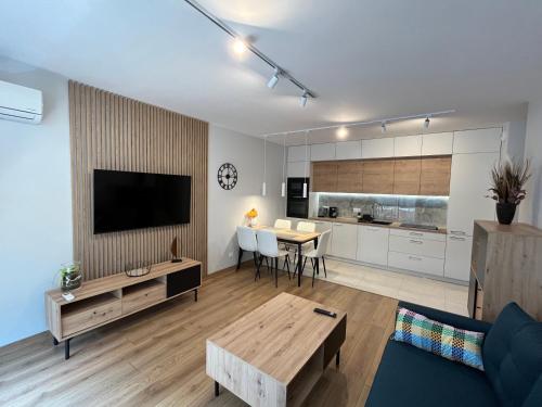 een woonkamer met een bank, een tv en een tafel bij Apartament 45 in Wrocław