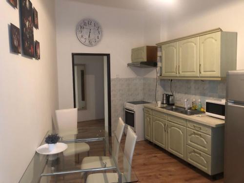 Una cocina con una mesa y un reloj en la pared. en Nette Wohnung in der Altstadt 2, en Cheb