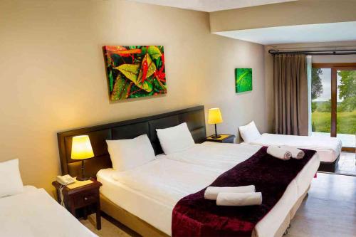 a hotel room with two beds and two lamps at İstanbul Airport Durusu Club Hotel in Arnavutk&ouml;y