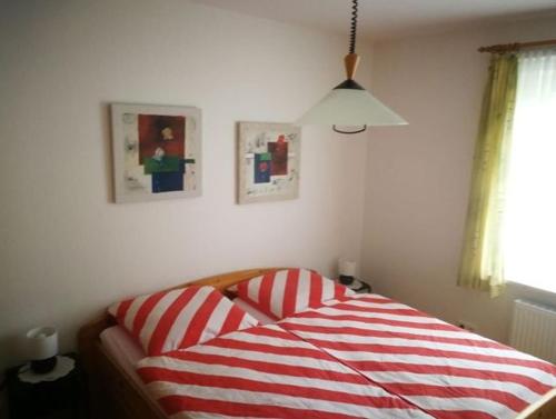 a bedroom with a red and white striped bed at FeWo Grüne Wiese 