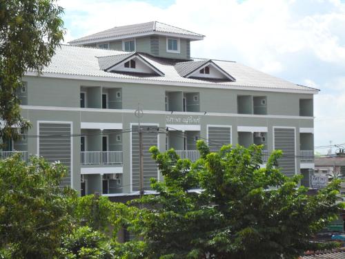 a large white building with trees in front of it at Tisaraporn Resident in Ban Khlong Song (1)