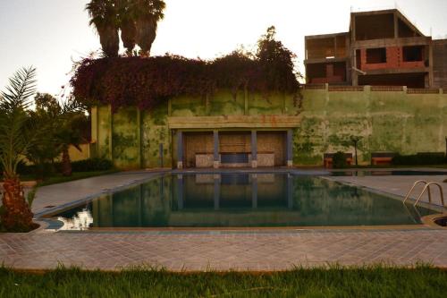 an old building with a swimming pool in a yard at Luxury flat in Mohamadia. in Mohammedia