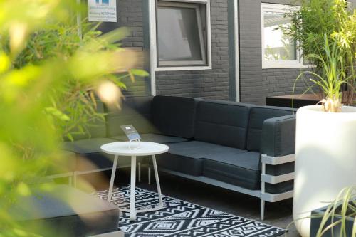 a blue couch on a patio with a table at Hotel Haverkamp in Bremerhaven