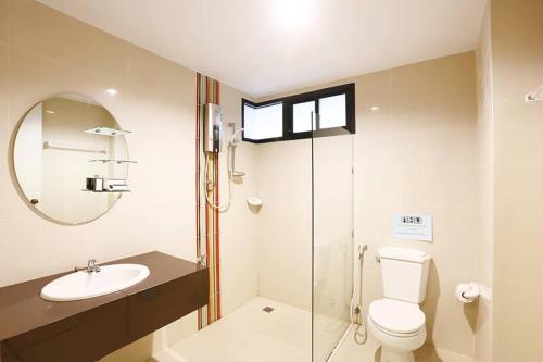 a bathroom with a toilet and a sink and a mirror at The Luxury Residence in Songkhla