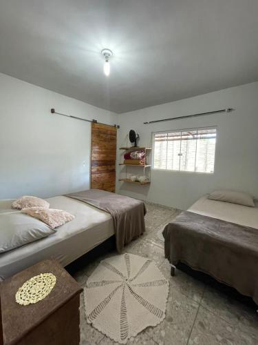 1 dormitorio con 2 camas y ventana en Casa na canastra DUDU en São Roque de Minas