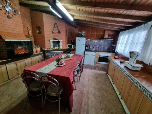 a kitchen with a table with a red table cloth at Quinta do Ribeiro - Covilhã - Serra da Estrela in Covilhã