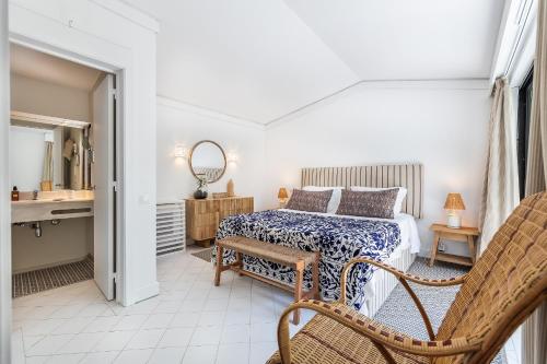 a bedroom with a bed and a sink and a mirror at Quinta do Lago, Victory Village N 63 in Almancil