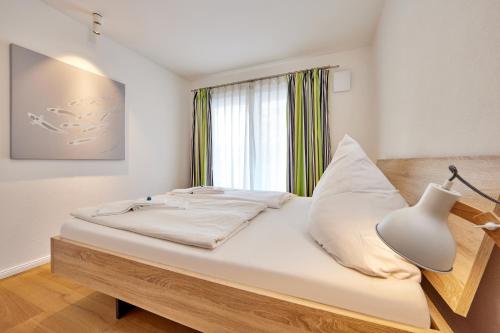 a bedroom with a bed with a lamp and a window at BergIdylle 2 in Garmisch-Partenkirchen