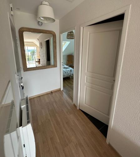 un couloir avec une porte et un miroir et une chambre dans l'établissement Appartement vue mer exposé sud à Carantec, à Carantec