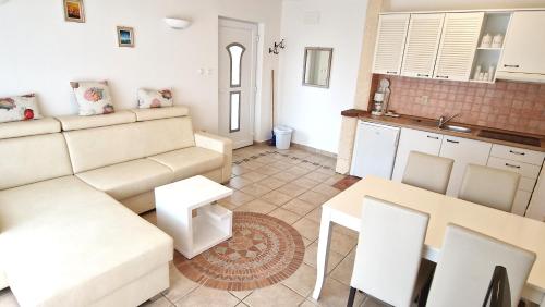 ein Wohnzimmer mit einem Sofa und einem Tisch in der Unterkunft Apartment Damijan in Krk