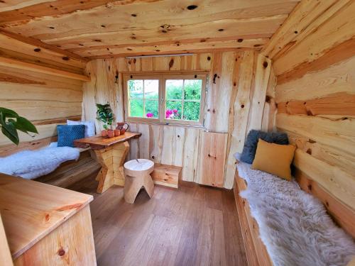 a log cabin with a table and a window at Unique wooden holiday house in nature in Lukovica pri Domžalah