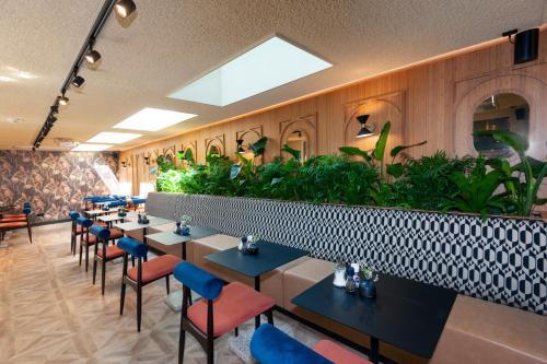 a restaurant with tables and chairs and plants at Hotel Nicolaas Witsen in Amsterdam