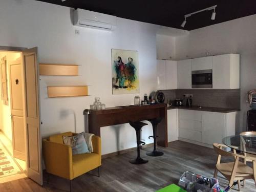 a kitchen with a table and a yellow chair in a room at Valletta Stylish City Pad in Valletta