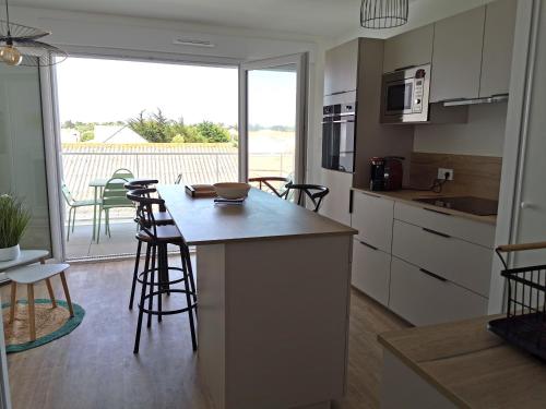 Il dispose d'un balcon et d'une cuisine avec une table et des chaises. dans l'établissement La Terrasse du SloI - Proche plage, à Notre-Dame-de-Monts