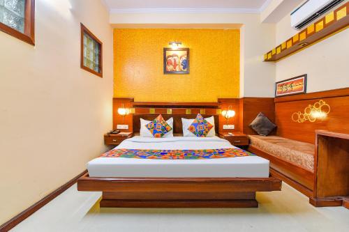 una camera con un grande letto e un divano di FabHotel Royal Residency a Jaipur