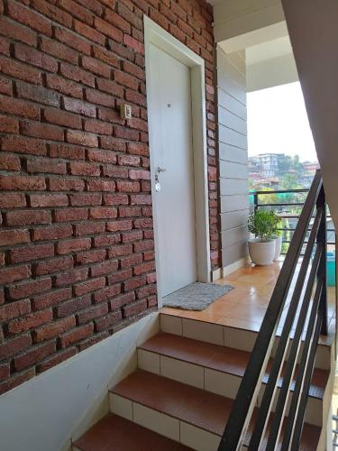 a brick wall and stairs with a white door at Lorin BnB in Kohīma