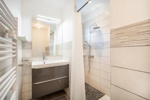 La salle de bains est pourvue d'un lavabo et d'une douche. dans l'établissement Entre lacs & Océan - Maison climatisée avec jardin, à Vielle-Saint-Girons
