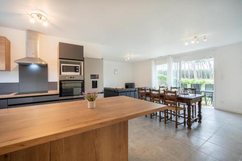 une grande cuisine avec une table et des chaises en bois dans l'établissement Entre lacs & Océan - Maison climatisée avec jardin, à Vielle-Saint-Girons