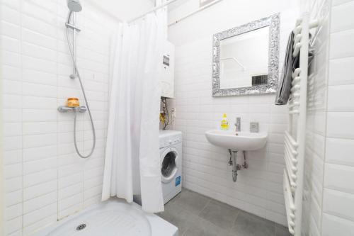 a white bathroom with a washing machine and a sink at Cityscape Apartments Mosonyi in Budapest