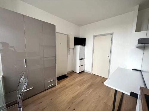 une cuisine blanche avec une table et un réfrigérateur dans l'établissement Le Petit Albert - Coeur de ville, à La Rochelle