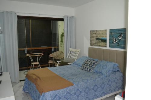 um quarto com uma cama, uma mesa e uma cadeira em Flat Fazenda Monte Castelo Gravatá em Gravatá