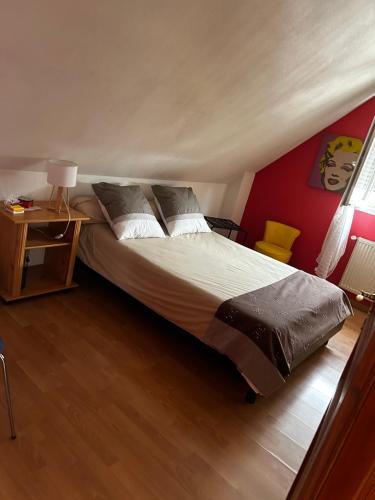 a bedroom with a large bed with a red wall at Maison privée in Kingersheim