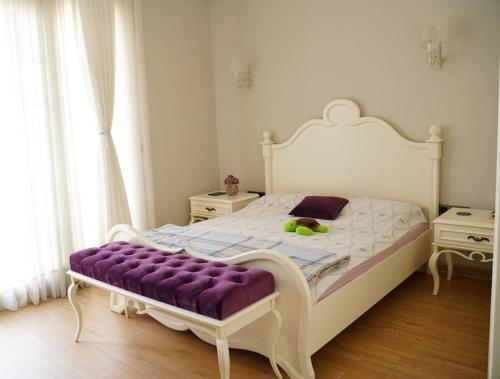 1 dormitorio con 1 cama blanca grande con manta morada en Luxury Villa Narlıdere, en Narlıdere