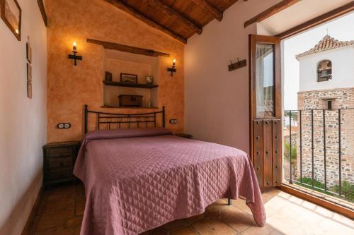 a bedroom with a bed and a large window at El Porton in Borge