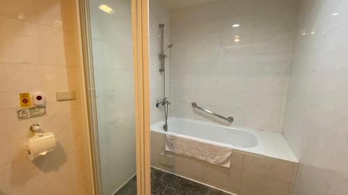 a bathroom with a shower and a tub and a sink at 文化信然 in Tainan