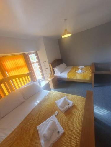 een hotelkamer met 2 bedden en handdoeken op de vloer bij Guardian View in Abertillery