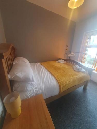 um quarto com uma cama com um cobertor amarelo em Guardian View em Abertillery